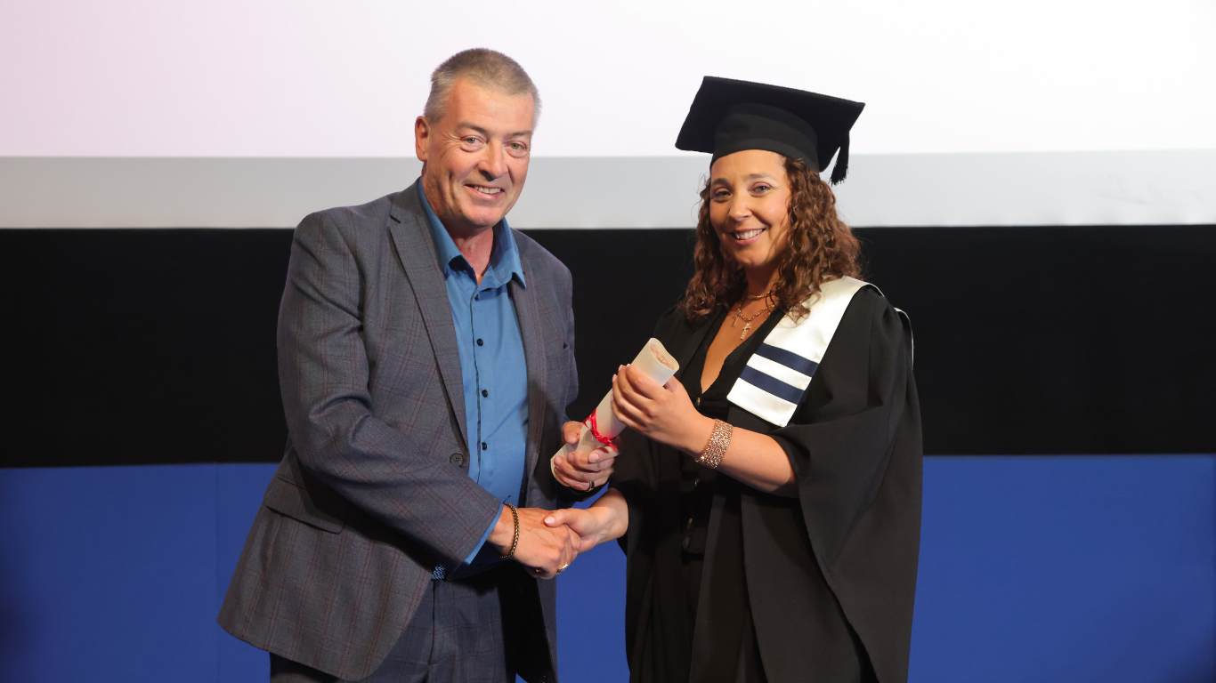 A FIT learner receiving their tech apprenticeship award on stage at graduation
